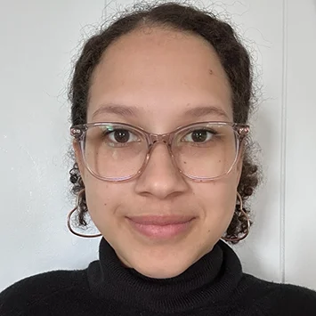 Maddie Alvarado, a latino woman with brown hair and glasses