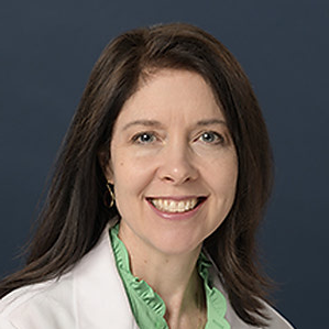 A white woman with dark hair in a lab coat