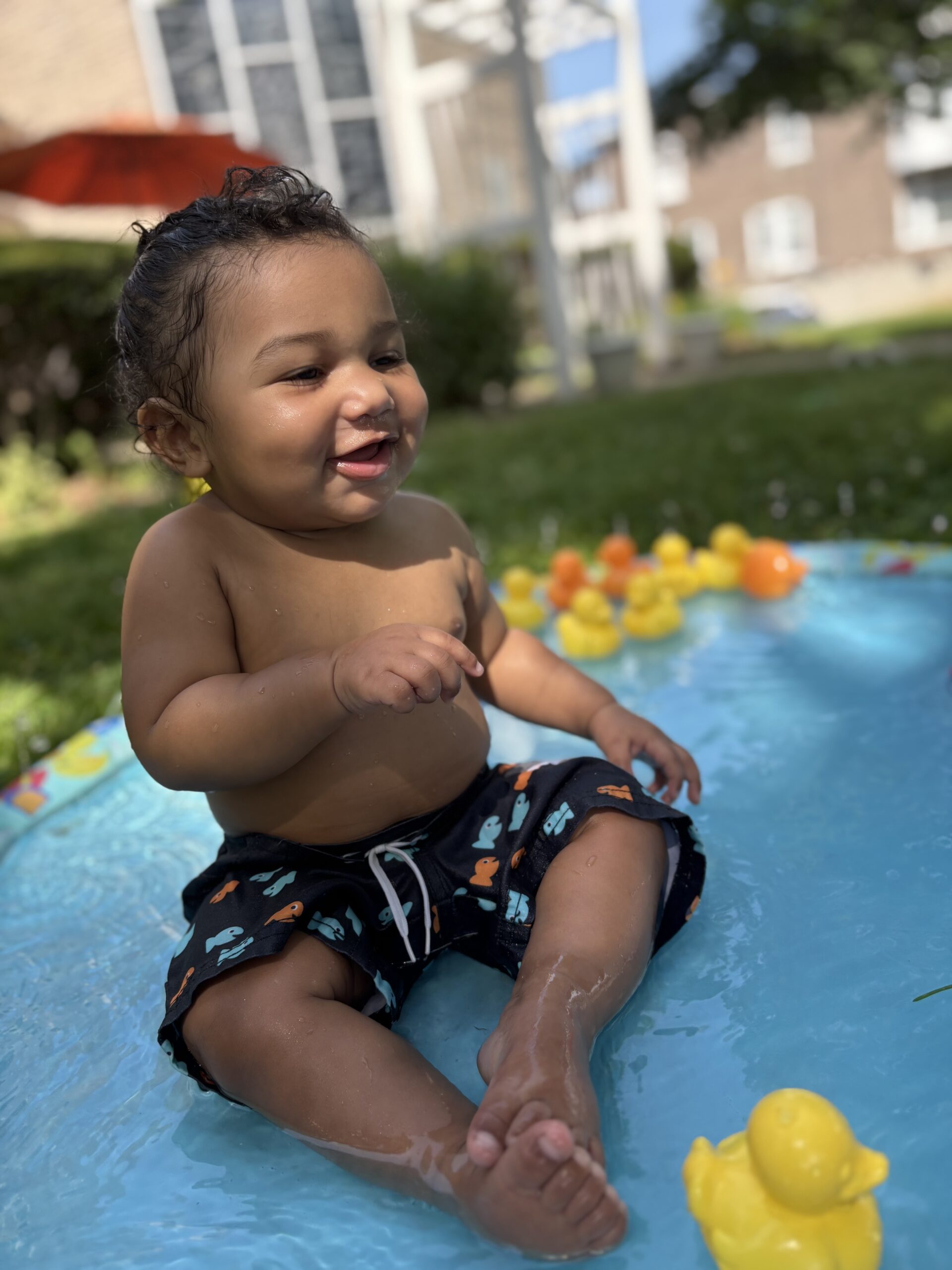 older baby boy stiing on splash pad