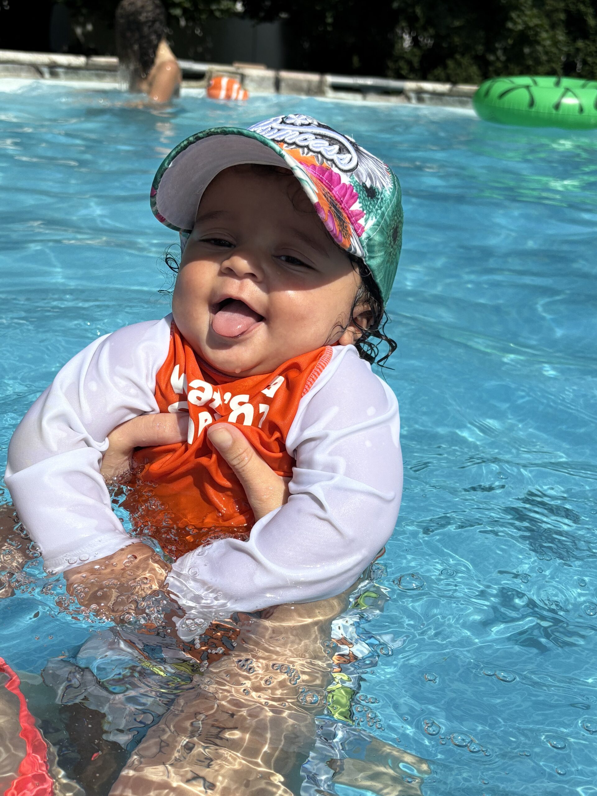 baby boy wearing a sunhat in a pool