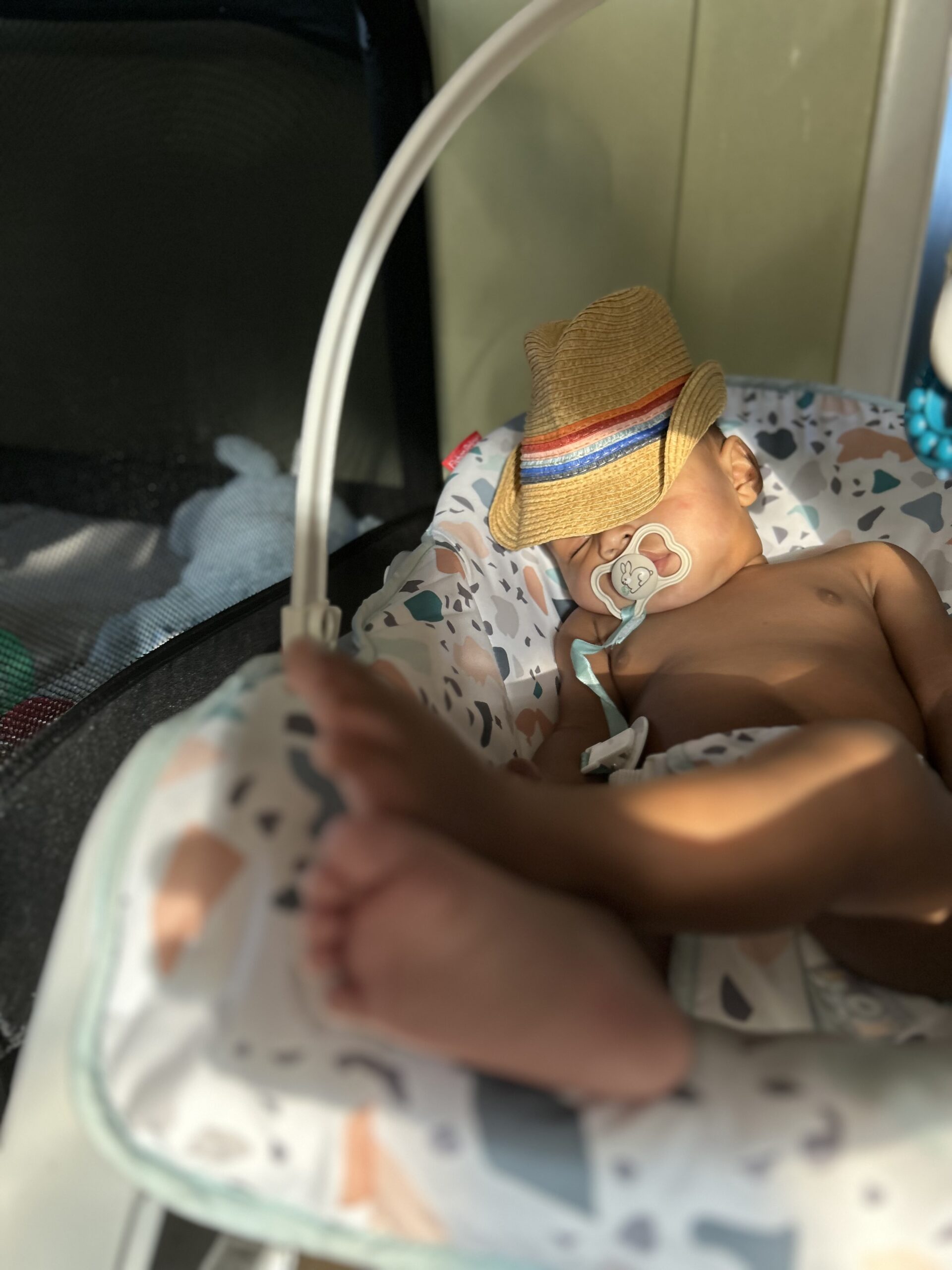 older baby sleeping in a swing