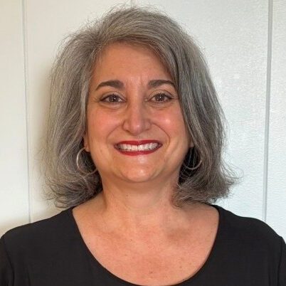 Paula Albanese, a white woman with medium length grey hair and a black shirt